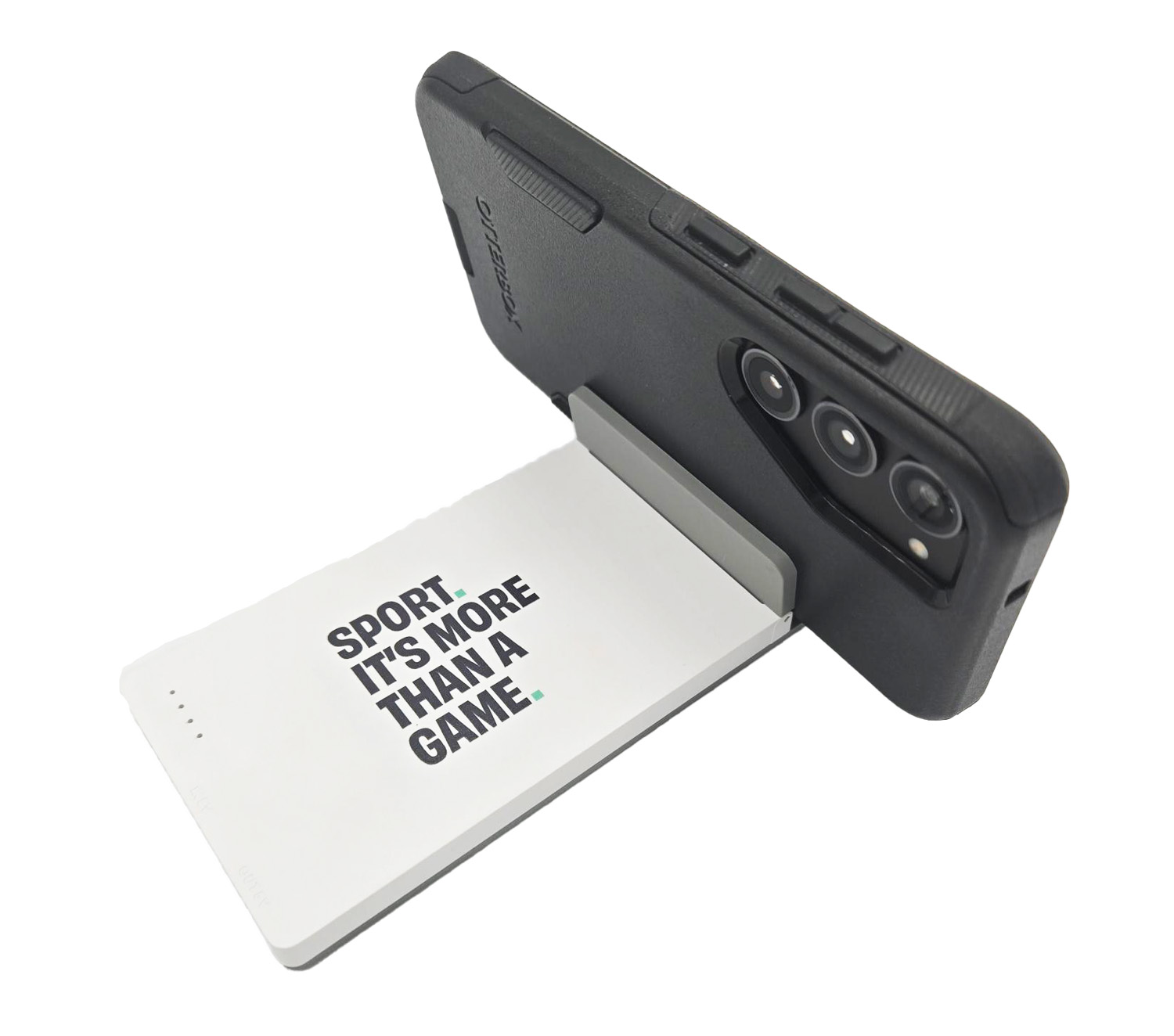 Photo of the white Sport. It's More Than A Game. power bank with a phone in the phone stand.